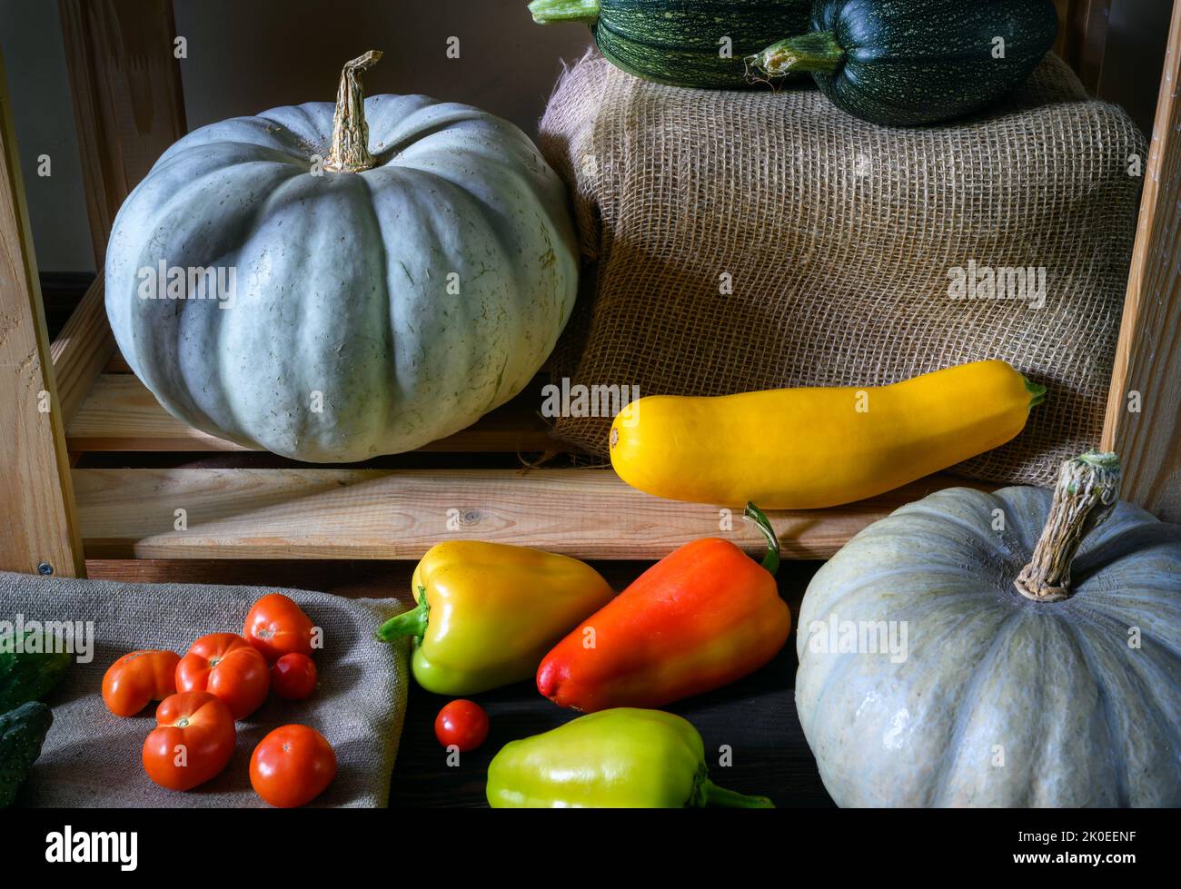 Médula vegetal, pimiento dulce y calabazas en la despensa, todavía la vida de los alimentos orgánicos en los estantes de madera. Calabacín y tomates en interior rústico. Cosecha Foto de stock