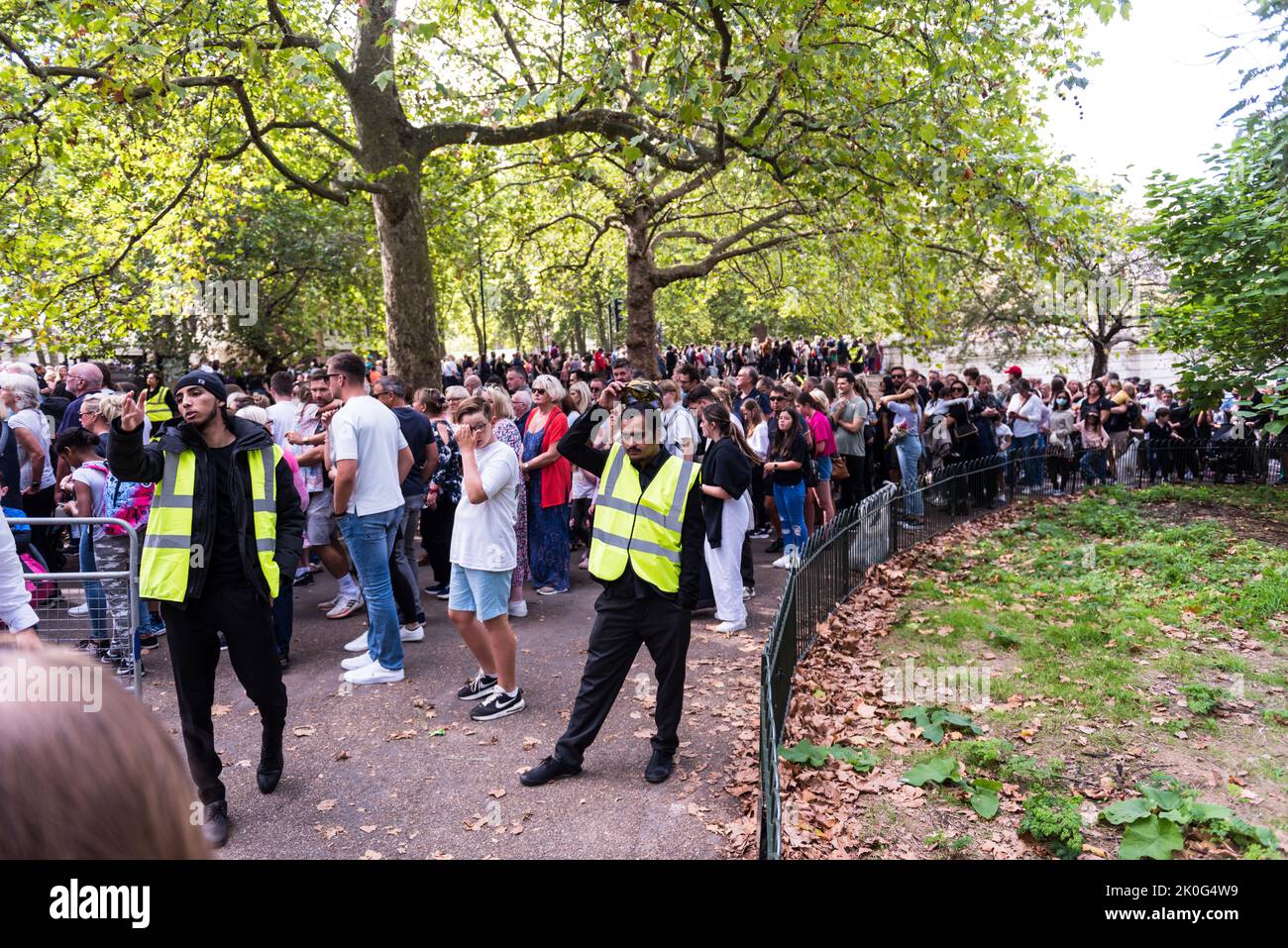 Gente esperando pacientemente en cola para respetar el Palacio de Buckingham Foto de stock