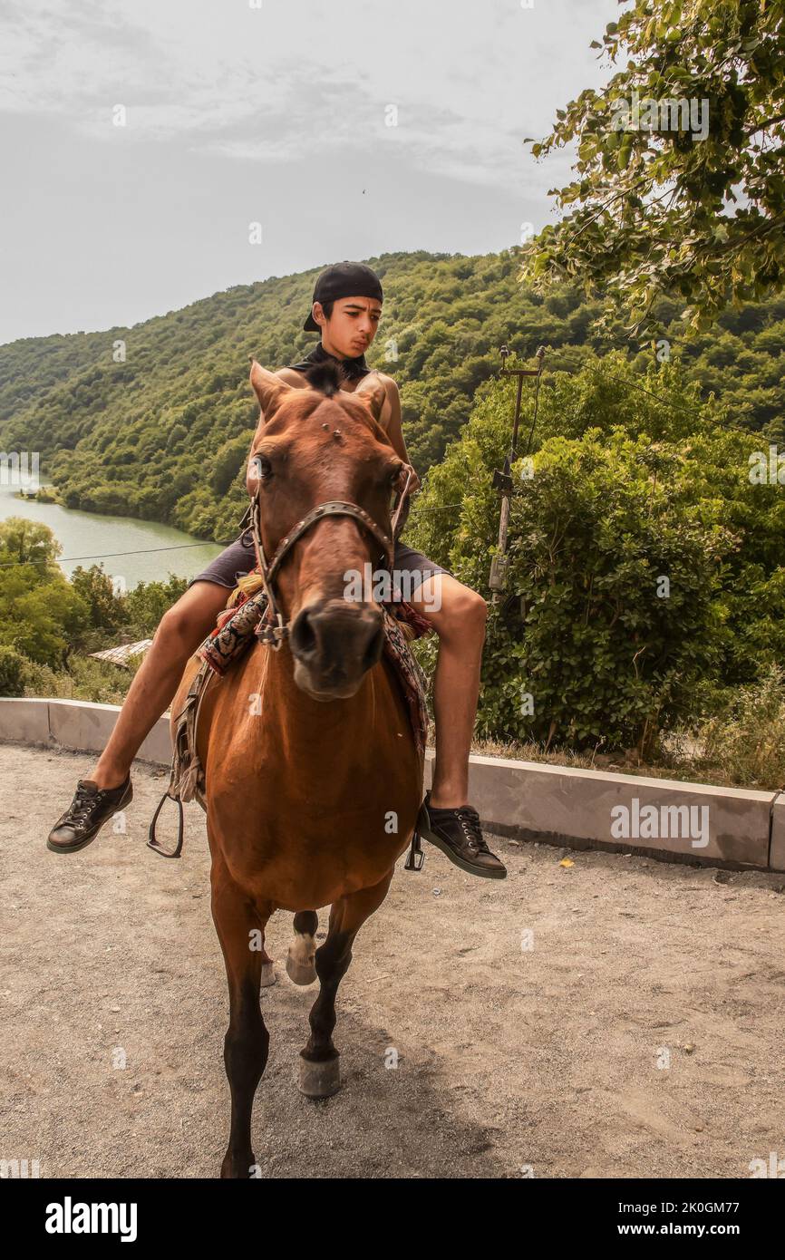 16 2019 de julio Mtskhea Georgia - Georgian boy on horse cerca del antiguo monasterio de Jvari - Motion blur Foto de stock