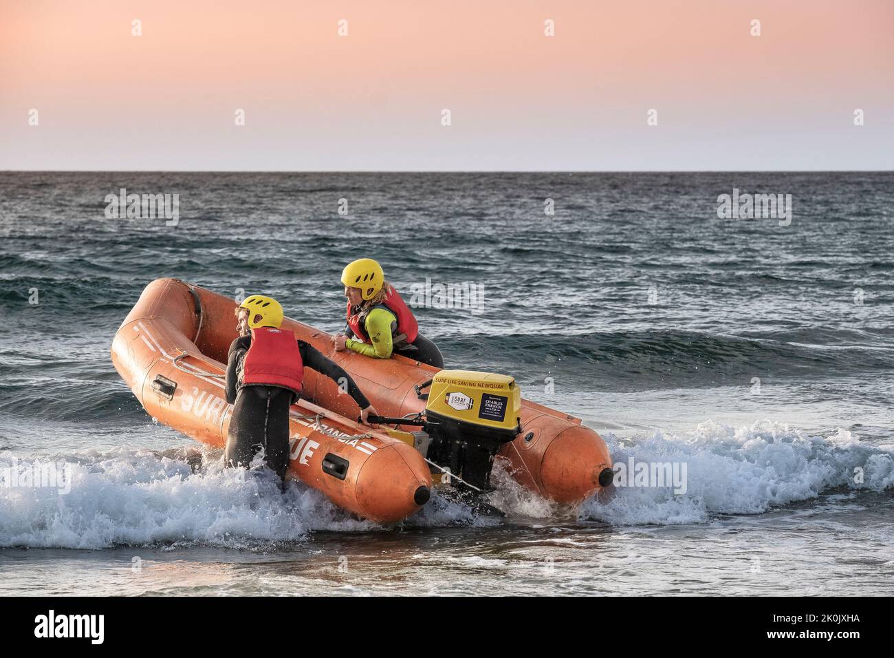 Miembros de Newquay Surf Life Saving Club lanzando una nave de rescate en tierra de clase Arancia para una sesión de entrenamiento en Fistral en Newquay en Cornwall en t Foto de stock