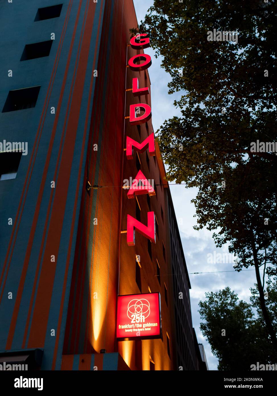 Cartel de Goldman del hotel 25hours. Logotipo vertical iluminado que brilla en la oscuridad de la mañana. Alojamiento turístico para turistas en la ciudad de Frankfurt. Foto de stock