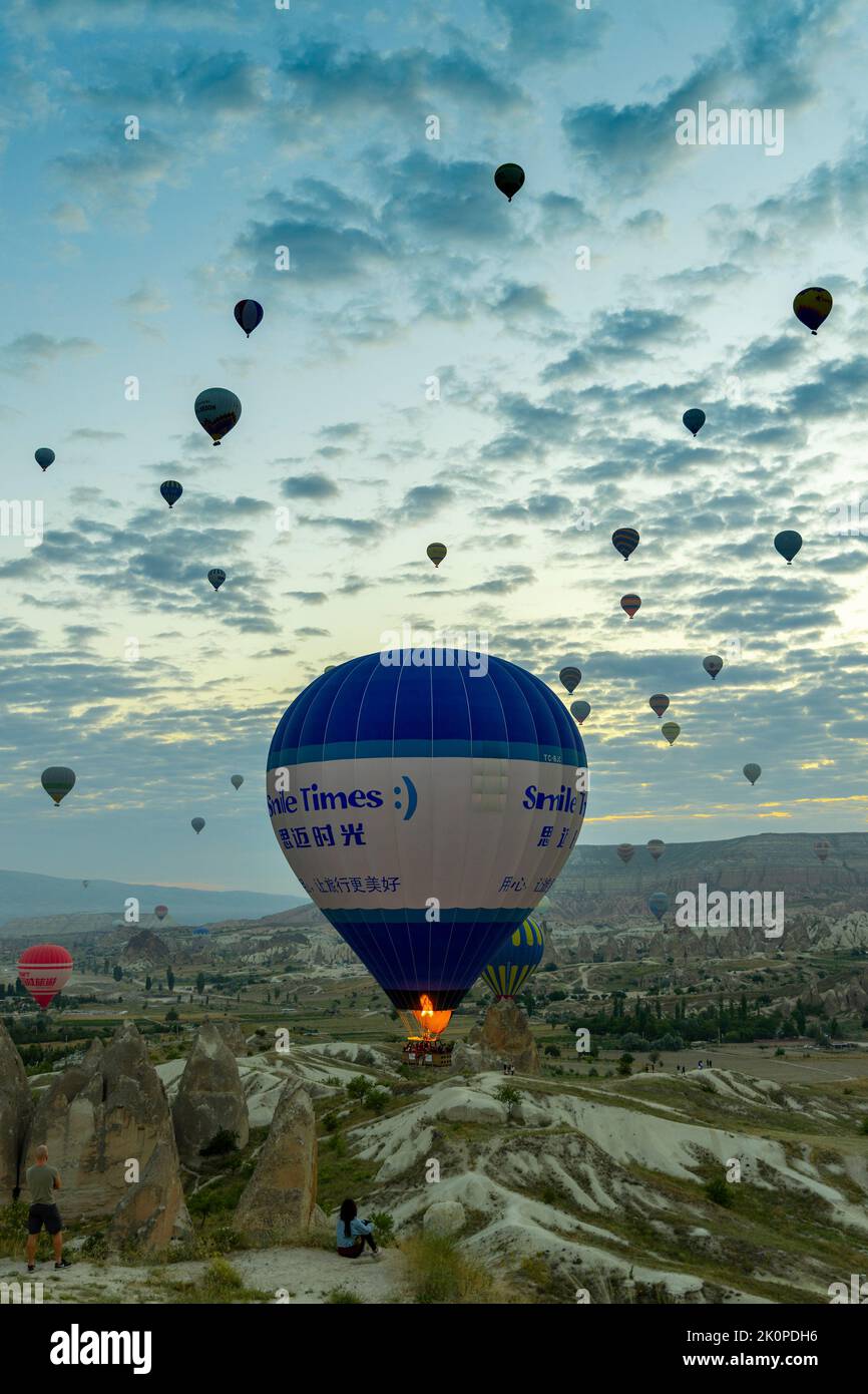 GOREME/TURQUÍA - 30 de junio de 2022: Los turistas ven el espectáculo de globos aerostáticos en Capadocia Foto de stock