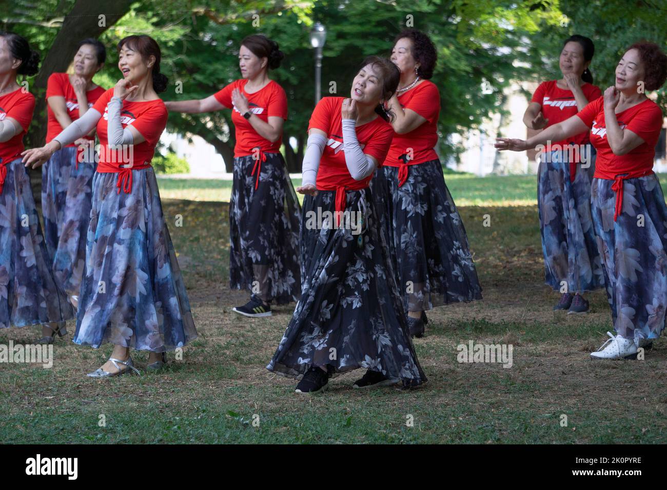 Mujeres chinas americanas en una clase diaria de baile y ejercicio yuanji en un parque en Queens, Nueva York. Es una tradición matutina china. Foto de stock