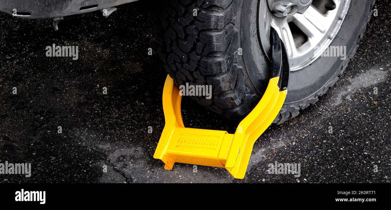 Arranque de rueda o bloqueo de neumático en un vehículo o coche por violación de estacionamiento ilegal Foto de stock
