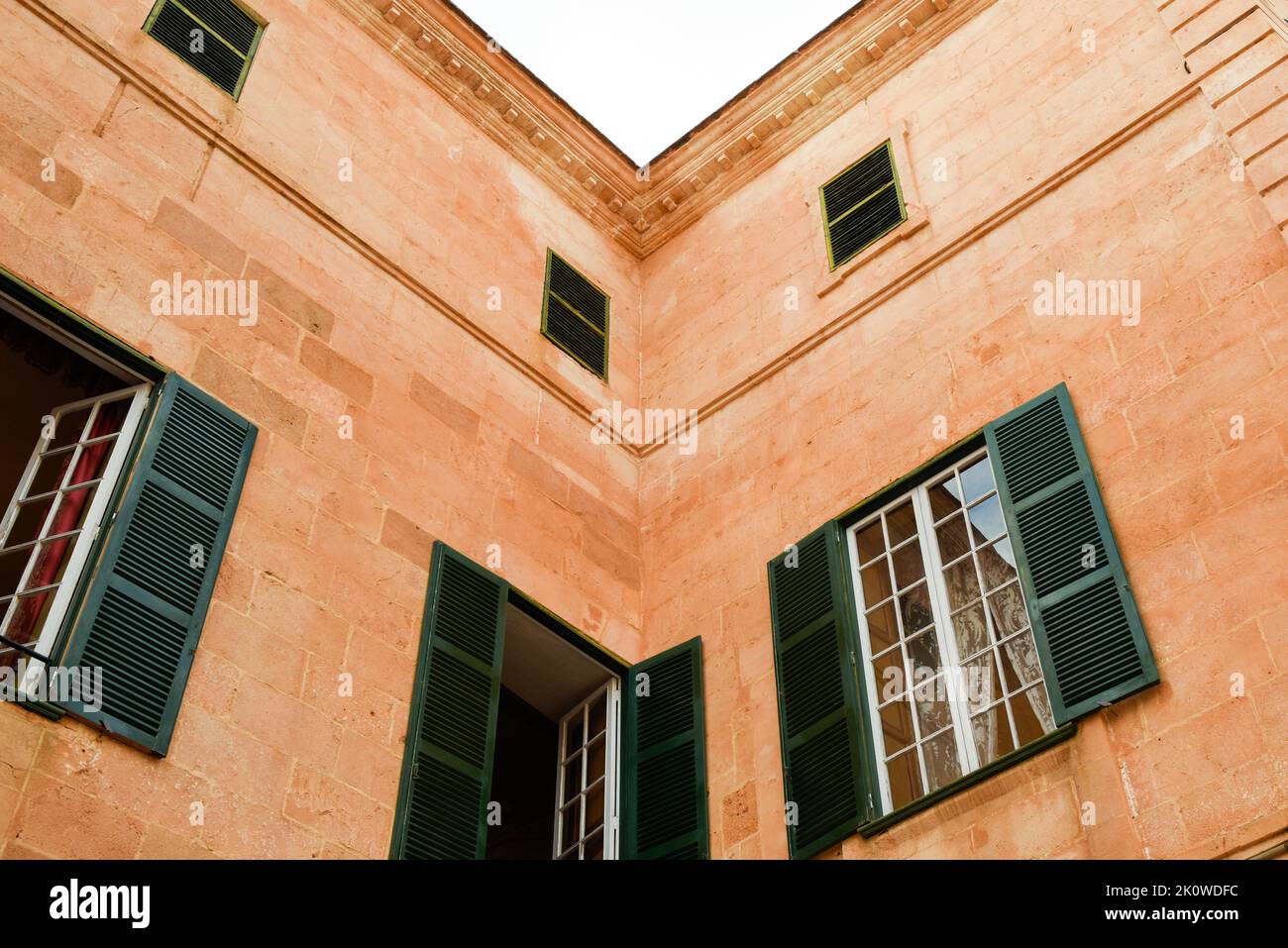 Resumen del exterior del edificio con detalles arquitectónicos y ventanas con persianas Foto de stock