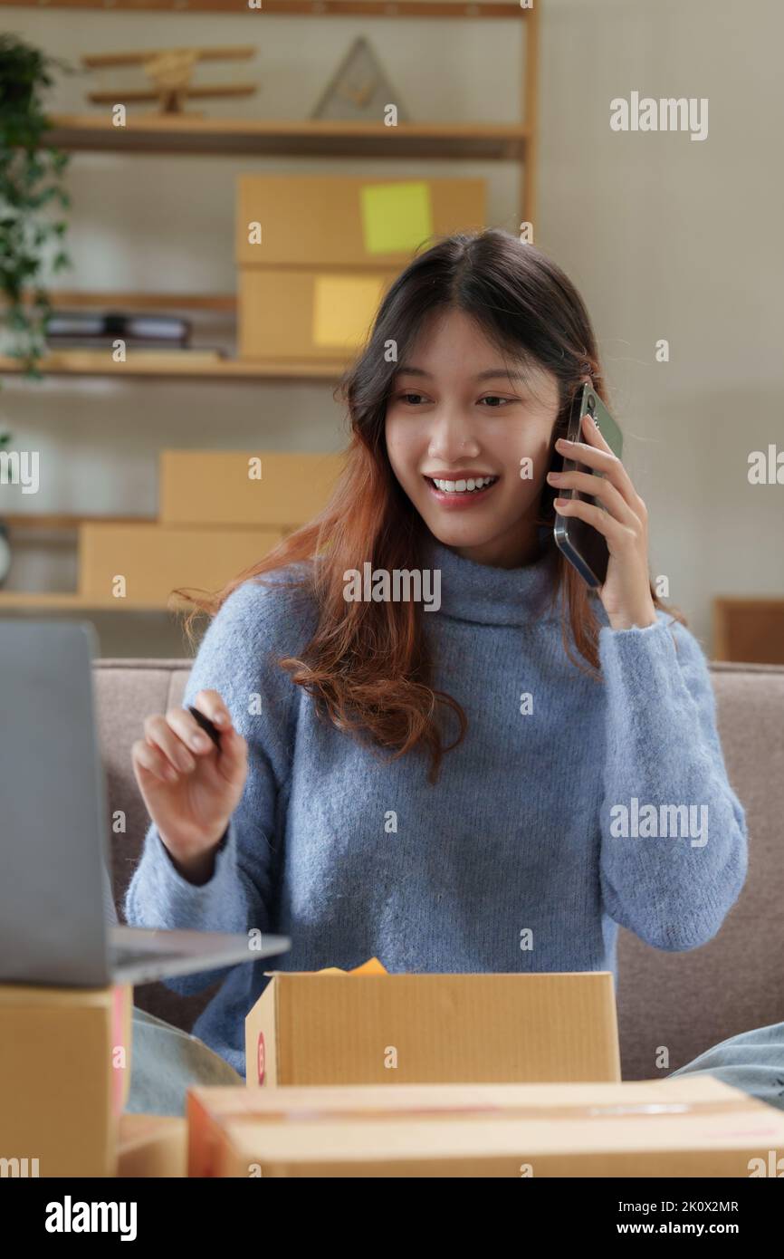Una mujer de negocios de pyme asiática hablando con el cliente por teléfono en la oficina en casa. Concepto de compras en línea Foto de stock