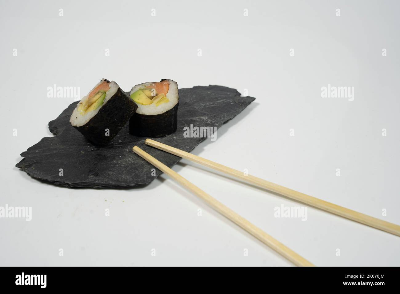 dos piezas de sushi en una pizarra con palillo, jengibre y wasabi Foto de stock