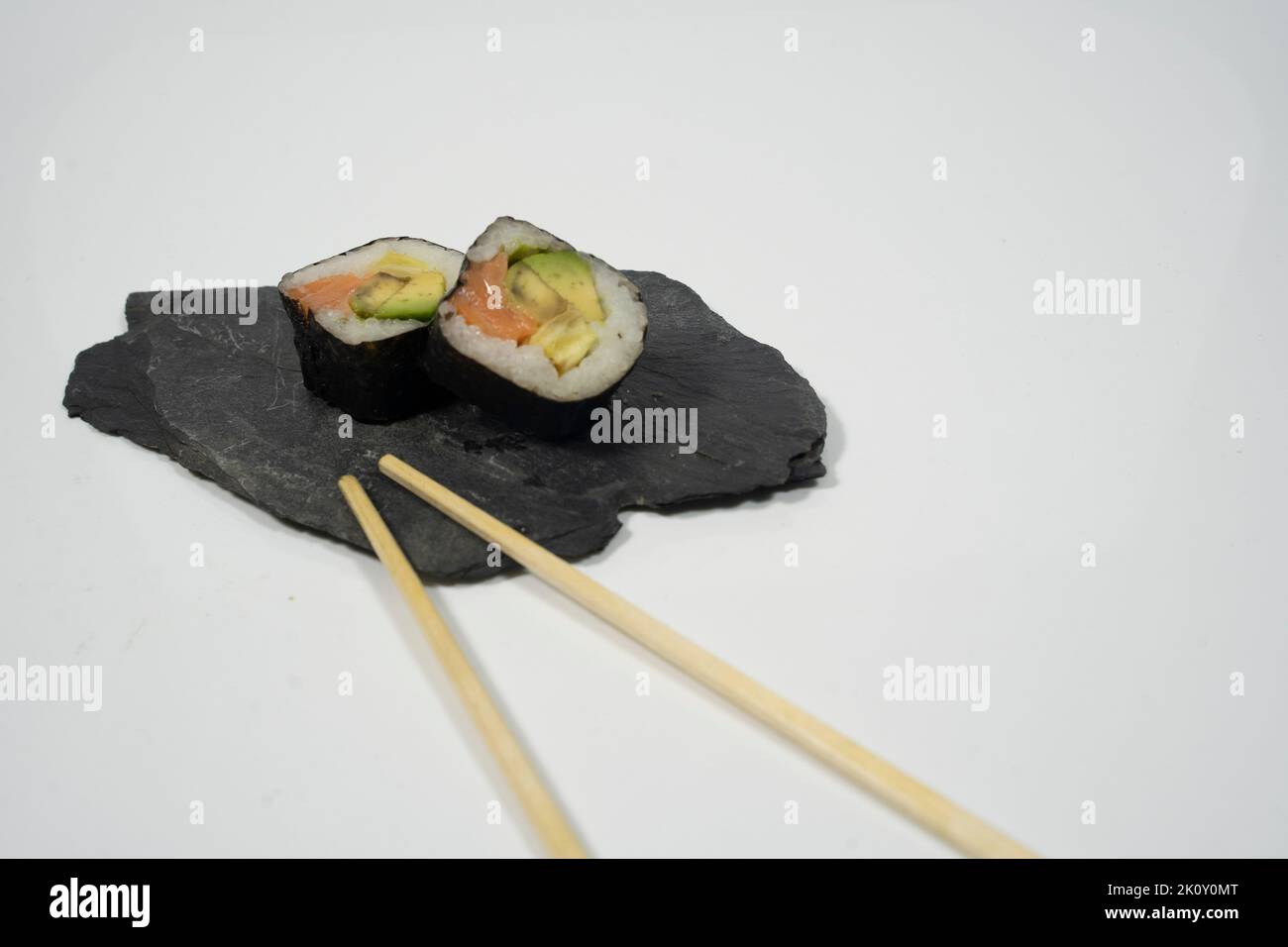 dos piezas de sushi en una pizarra con palillo, jengibre y wasabi Foto de stock