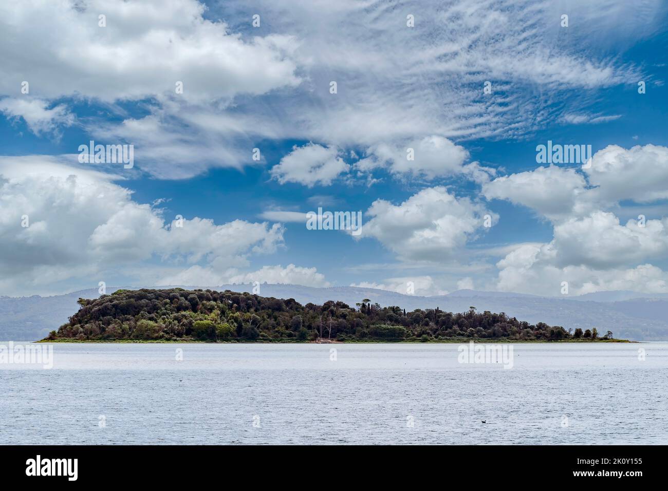 Isla de Isola Minore en el lago Trasimeno, vista desde Tuoro, Perugia Italia, bajo un hermoso cielo Foto de stock