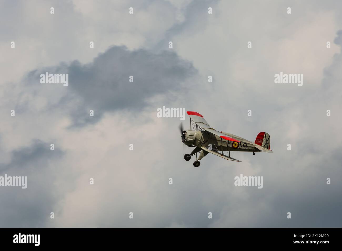 Bucker BU133 Jungmeister, G-BVXJ volando en el tiempo tormentoso Foto de stock