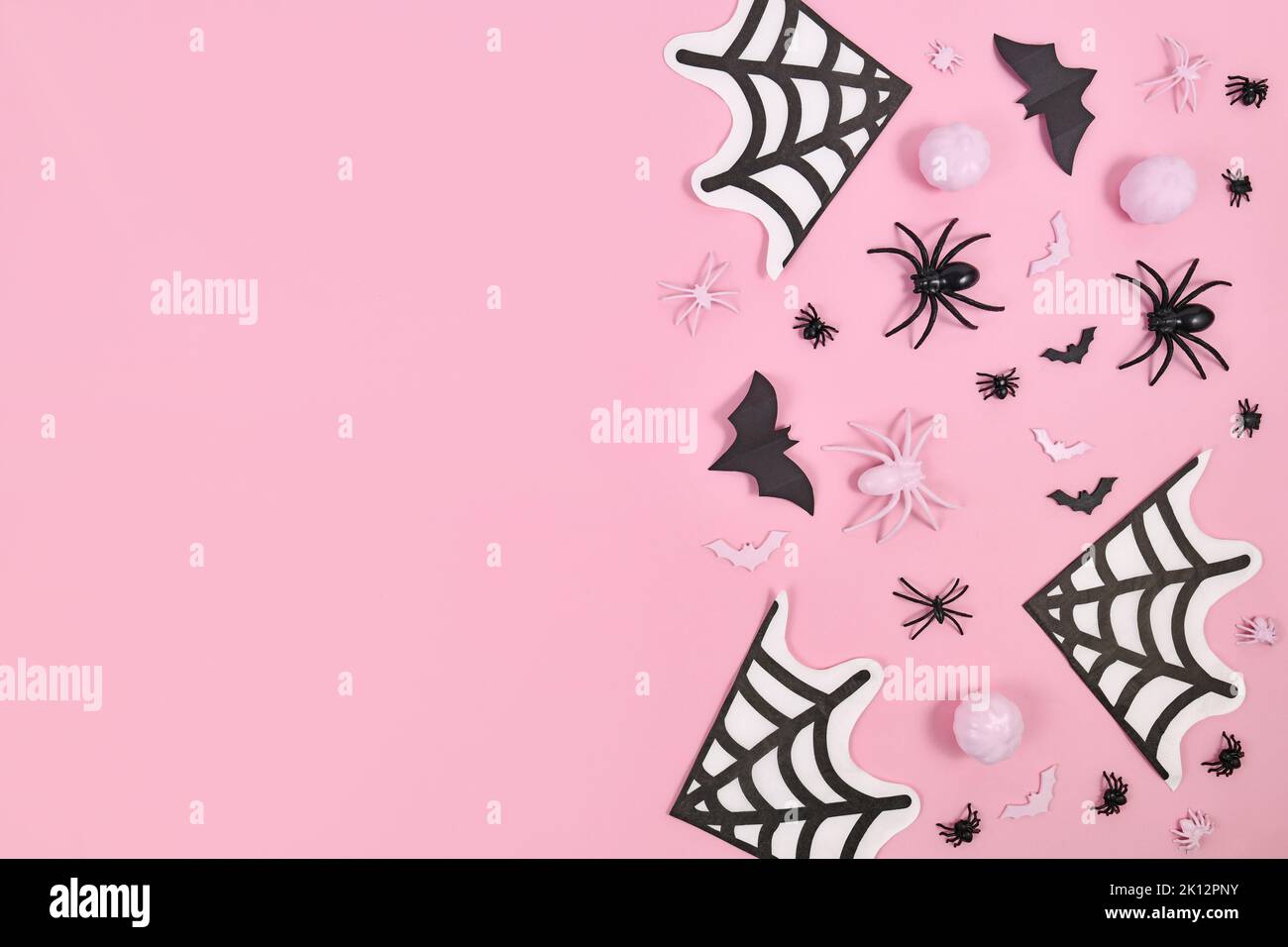 Decoración de Halloween rosa y negro en un lado de fondo rosa con espacio de copia Foto de stock