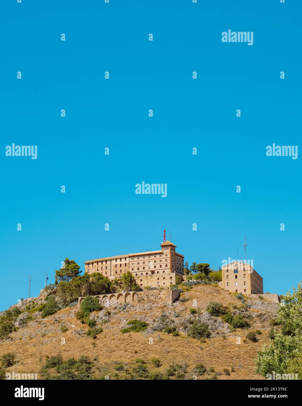 El Monasterio de El Pueyo en Barbastro, Aragón, España, en la cima de una montaña, contra el cielo azul, con un espacio en blanco en la parte superior Foto de stock