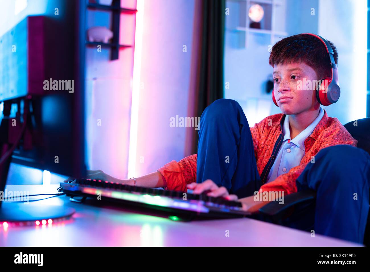 Aburrido niño adolescente soñoliento joven mientras juega un videojuego en línea en el ordenador en casa - concepto de pereza, insomnio y soledad. Foto de stock