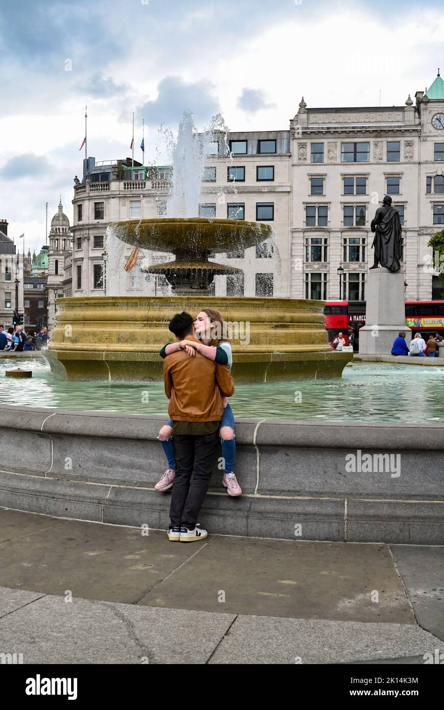 Trafalgar Square Londres Reino Unido - Pareja junto a una de las fuentes en la fotografía cuadrada tomada por Simon Dack Foto de stock