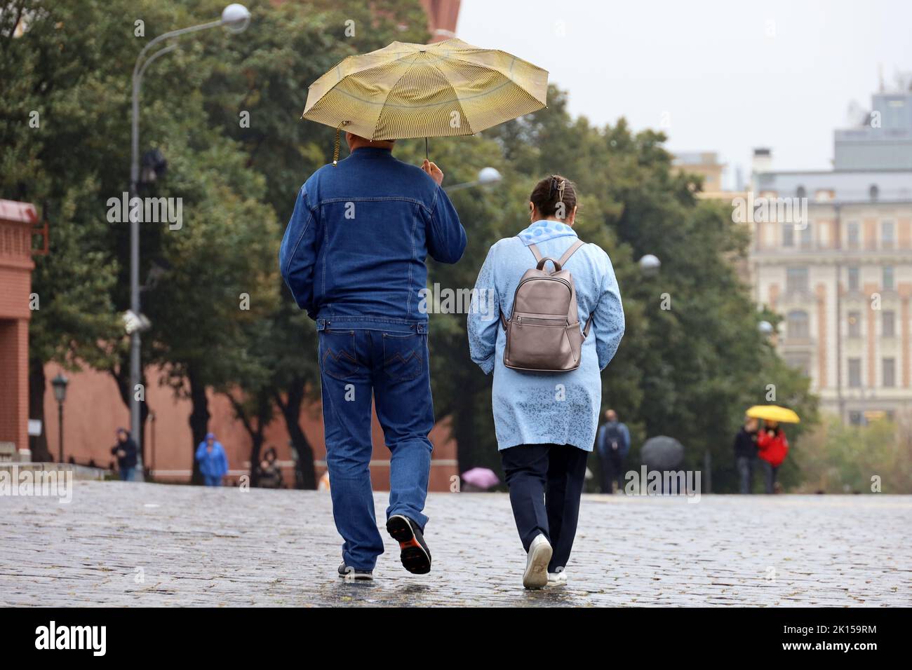 Lluvia en Moscú, pareja con un paseo paraguas en una calle. Clima lluvioso en la ciudad de otoño Foto de stock