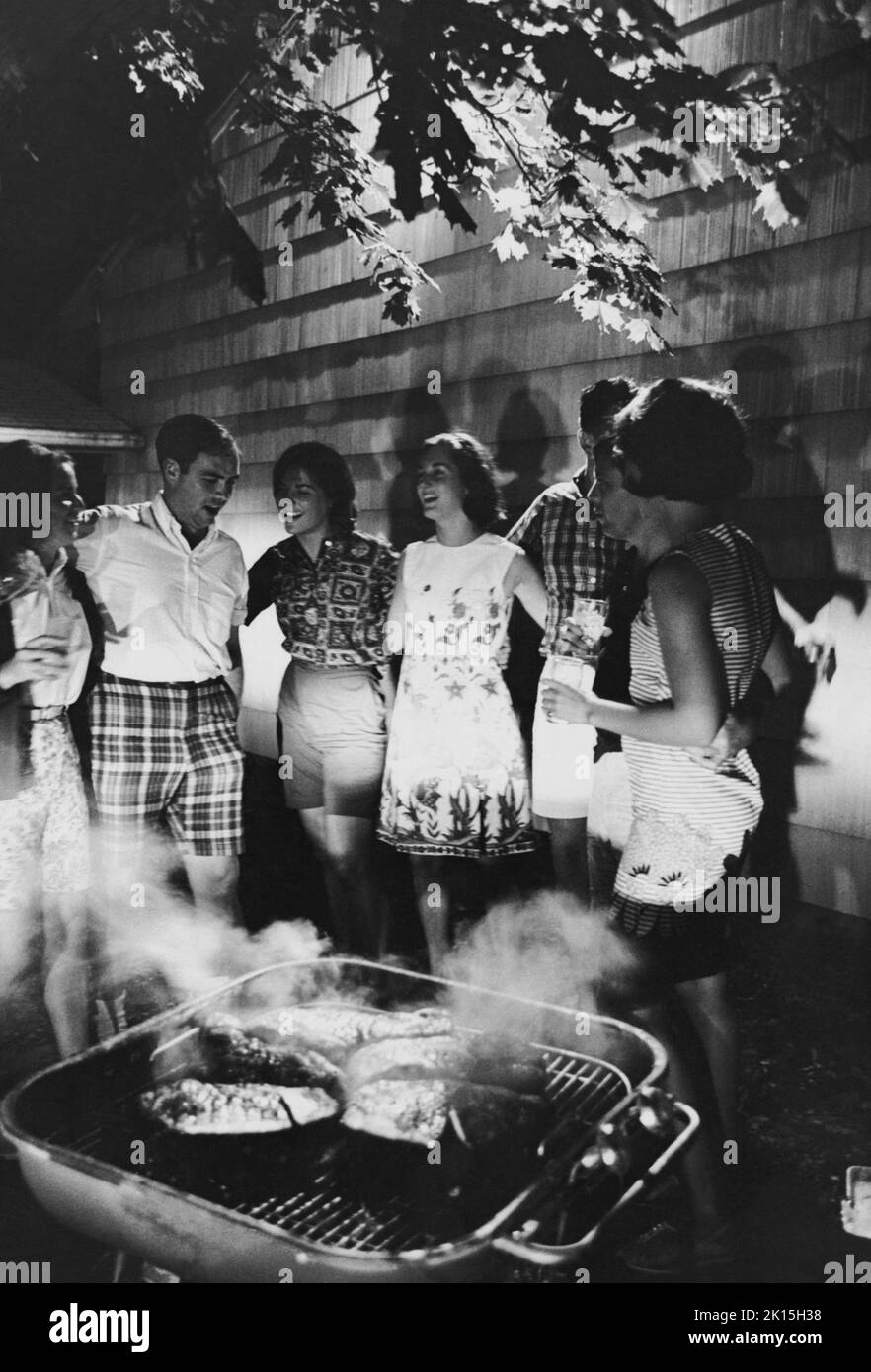 Los amigos se reúnen alrededor de la barbacoa; 1961. Foto de stock