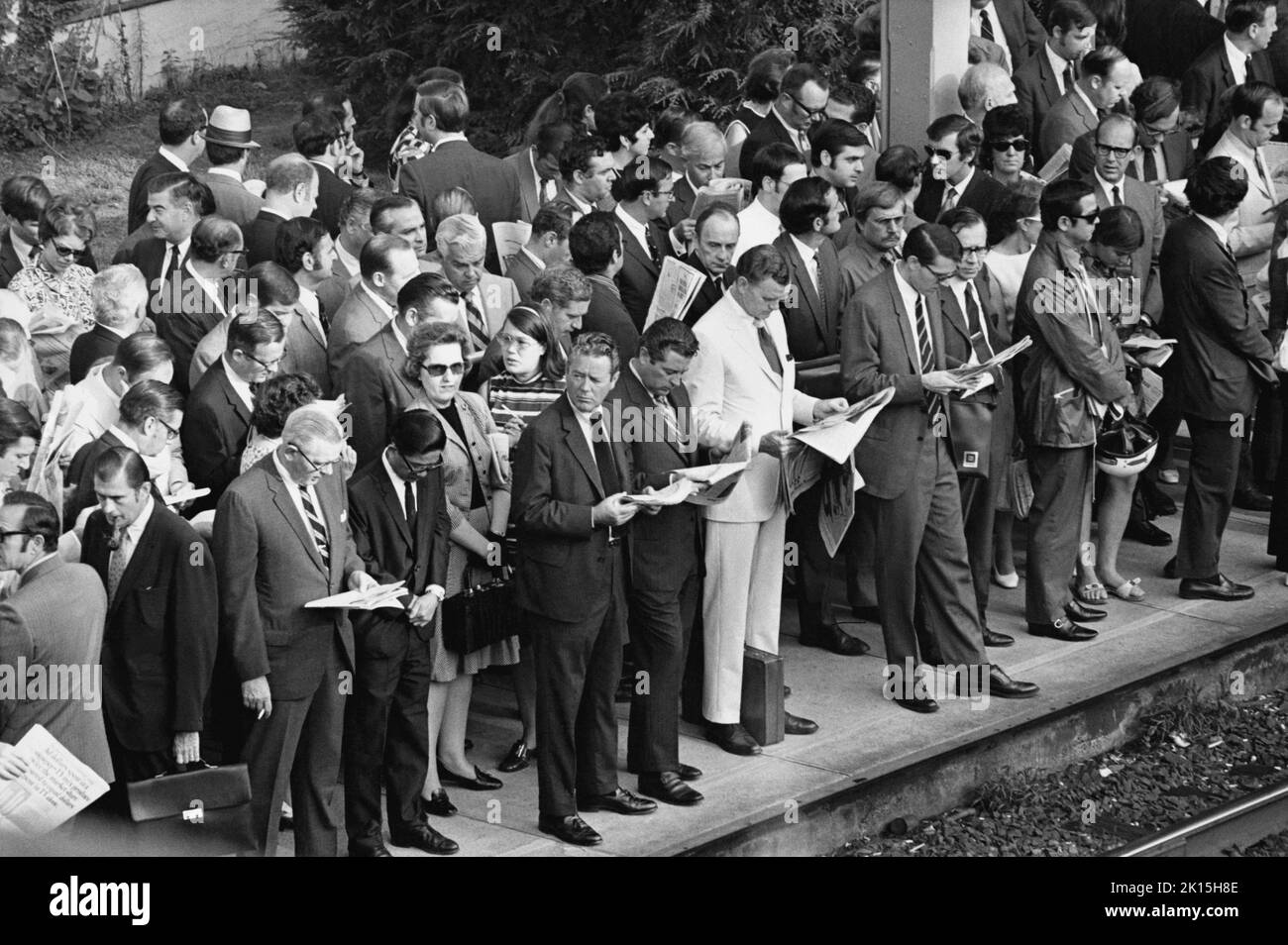 Pasajeros del tren Penn Central esperando en una plataforma abarrotada en Scarsdale, Nueva York, alrededor de 1976. La mayoría de la multitud es blanca y masculina, mientras que las mujeres son aproximadamente 1 en 7 de la fuerza laboral que se muestra aquí. Foto de stock