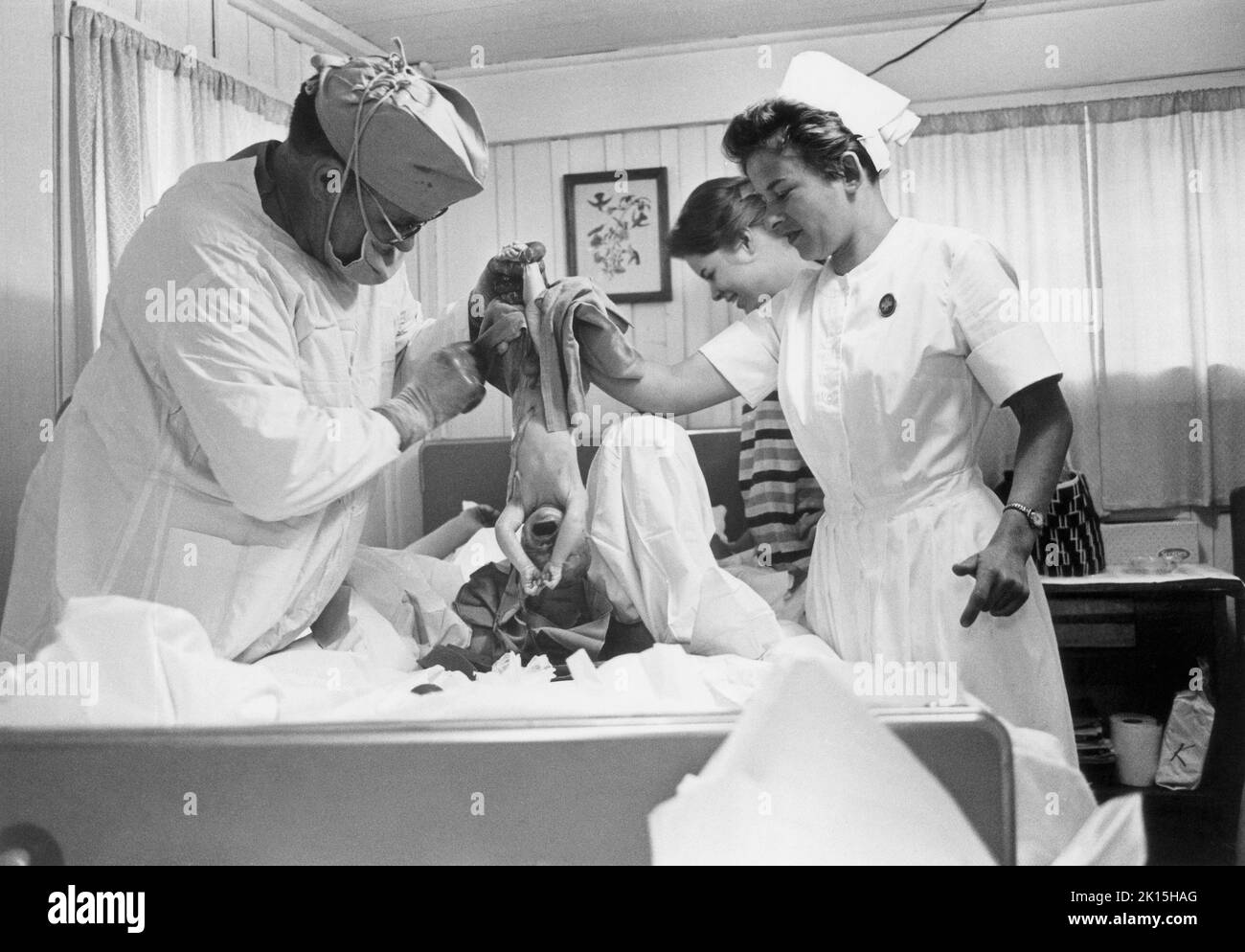 La Dra. Gaine Cannon entrega a un bebé en el ala de maternidad de dos habitaciones de una clínica en las Montañas Blue Ridge, cerca de Asheville, Carolina del Norte. 1983. Foto de stock