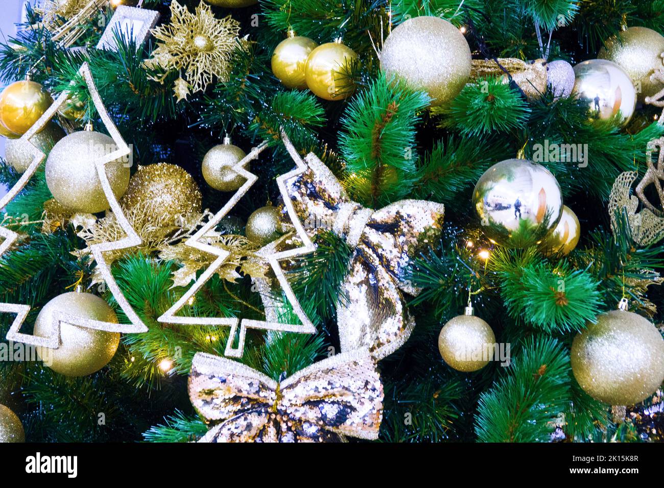 Una sección de un árbol de Navidad de Año Nuevo con juguetes e iluminación en un sombrío día de invierno crea una premonición de las vacaciones. La historia de la Natividad Foto de stock