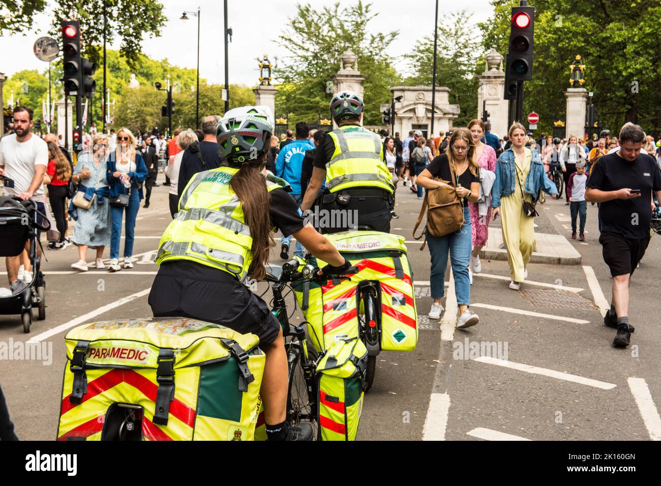 Paramédico en bicicleta navegando a través de la multitud peatonal cerca del Palacio de Buckingham Foto de stock