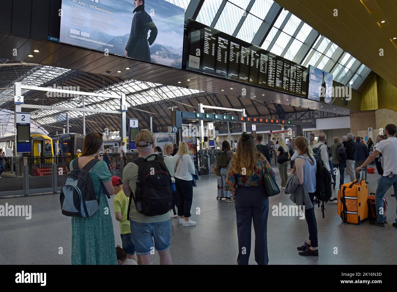 Pasajeros que esperan trenes viendo las tablas de salida en Queen Street Station, Glasgow, Escocia, Reino Unido Foto de stock