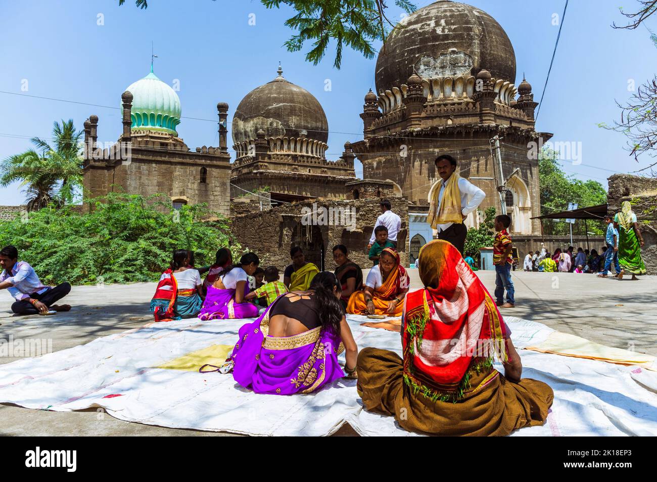 Bijapur, Karnataka, India : Los peregrinos se sientan fuera del sitio gemelo de peregrinación de las tumbas de 17th años de Jod Gumbad. Foto de stock