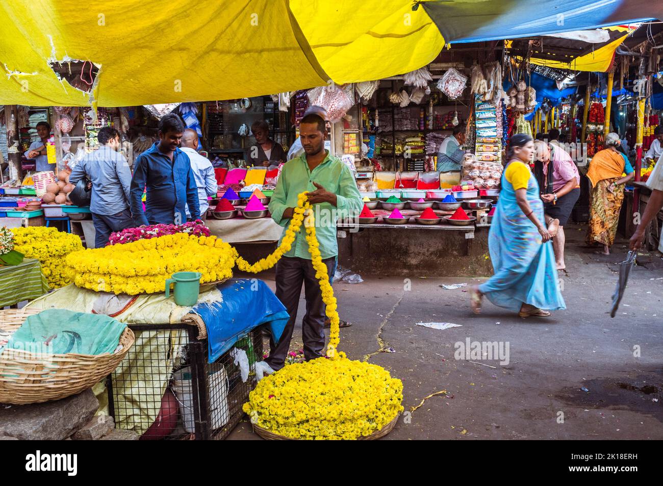Mysore, Karnataka, India: Un vendedor prepara la guarnición de la flor en un puesto en el mercado de Devaraja. Foto de stock
