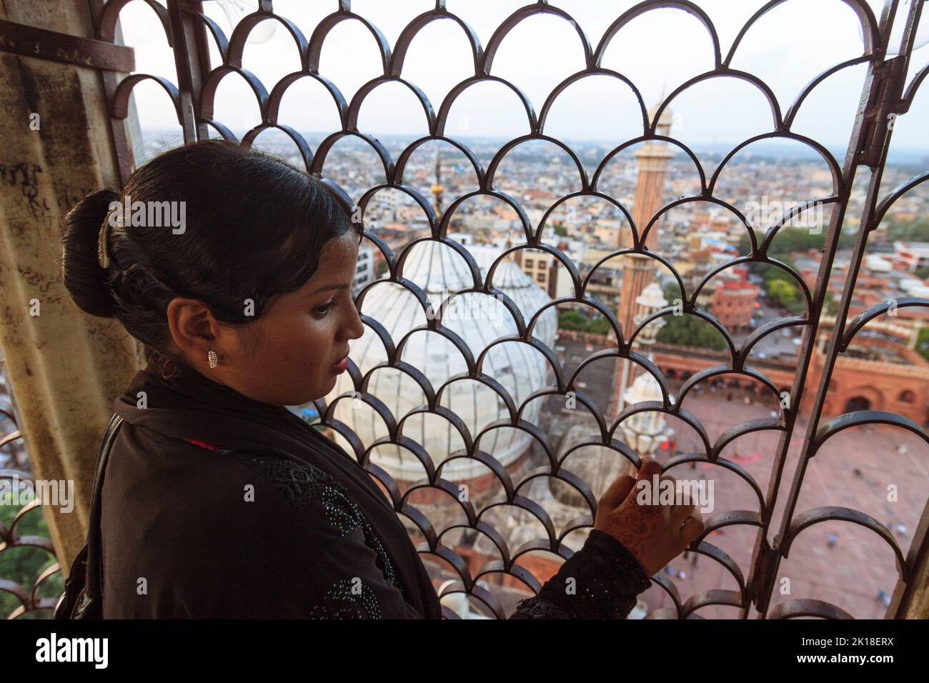 Delhi, India : Una mujer mira la vista de la Vieja Delhi y la Jamaa Masjid desde uno de los minaretes de la mezquita. Foto de stock