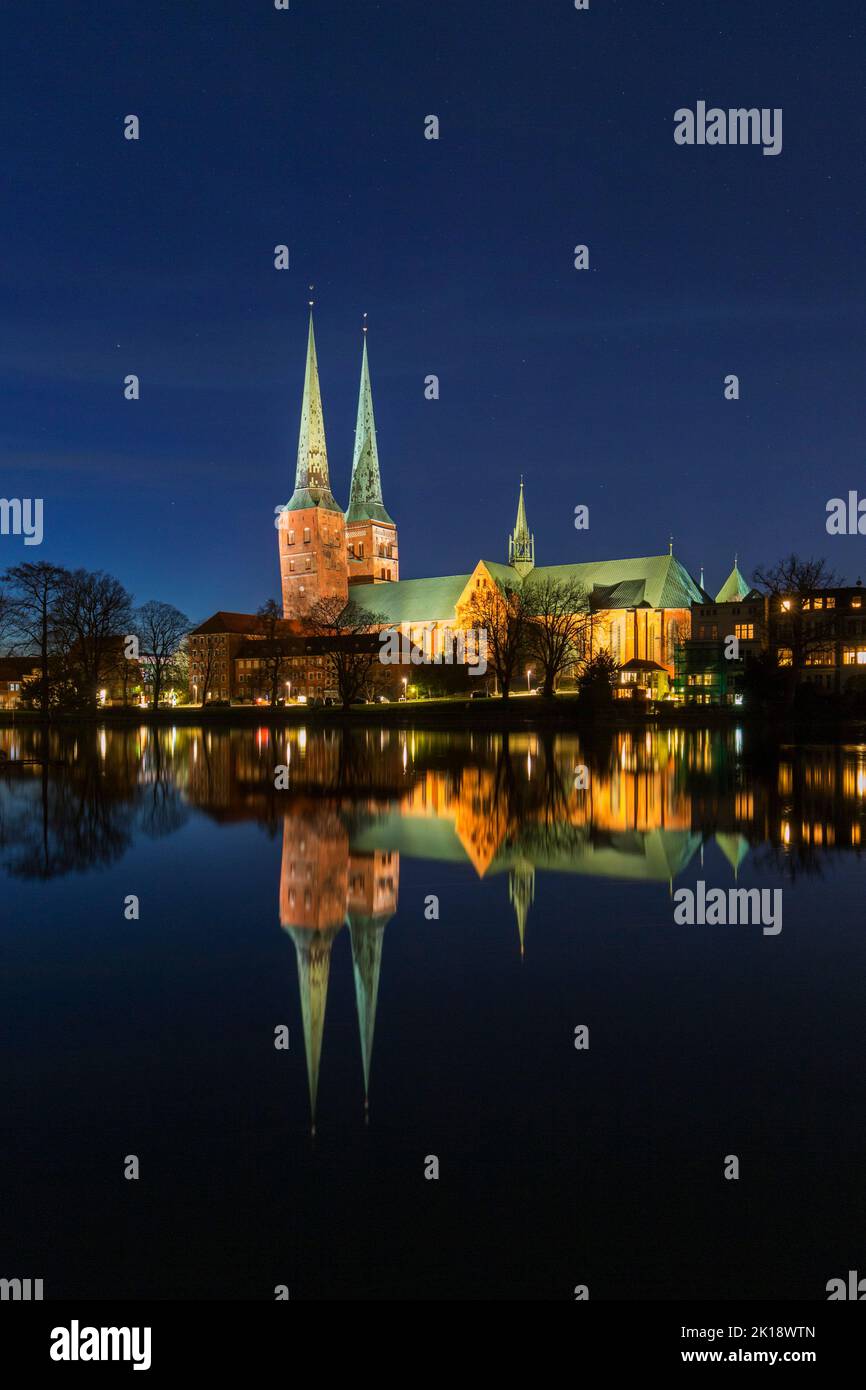 Catedral Dom zu Lübeck / Lübecker Dom reflejado en el agua del río Trave por la noche en la ciudad hanseática de Lübeck, Schleswig-Holstein, Alemania Foto de stock