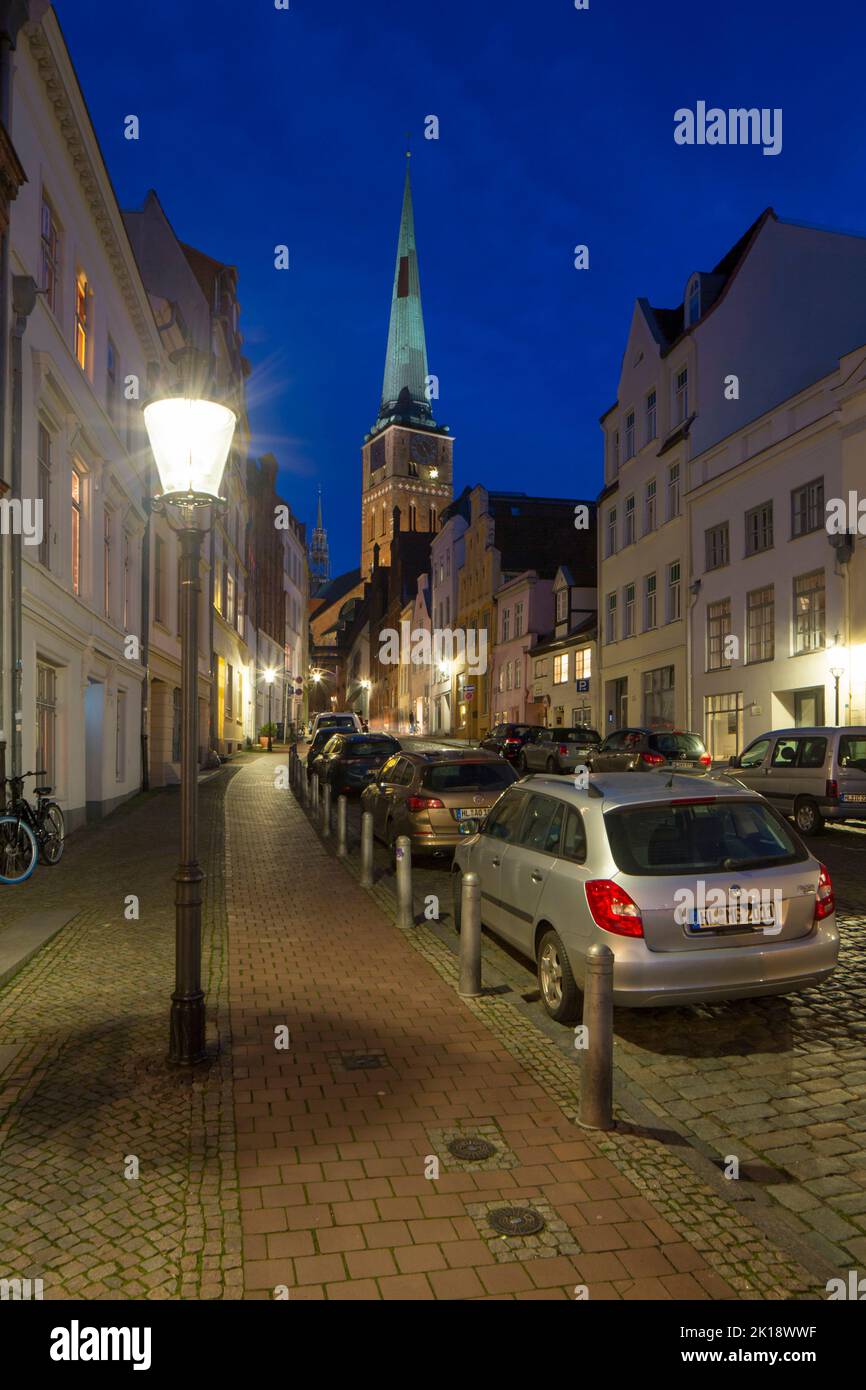 La iglesia y la calle de San Jakobikirche, de estilo gótico, con casas históricas en la ciudad hanseática de Lübeck por la noche, Schleswig-Holstein, Alemania Foto de stock