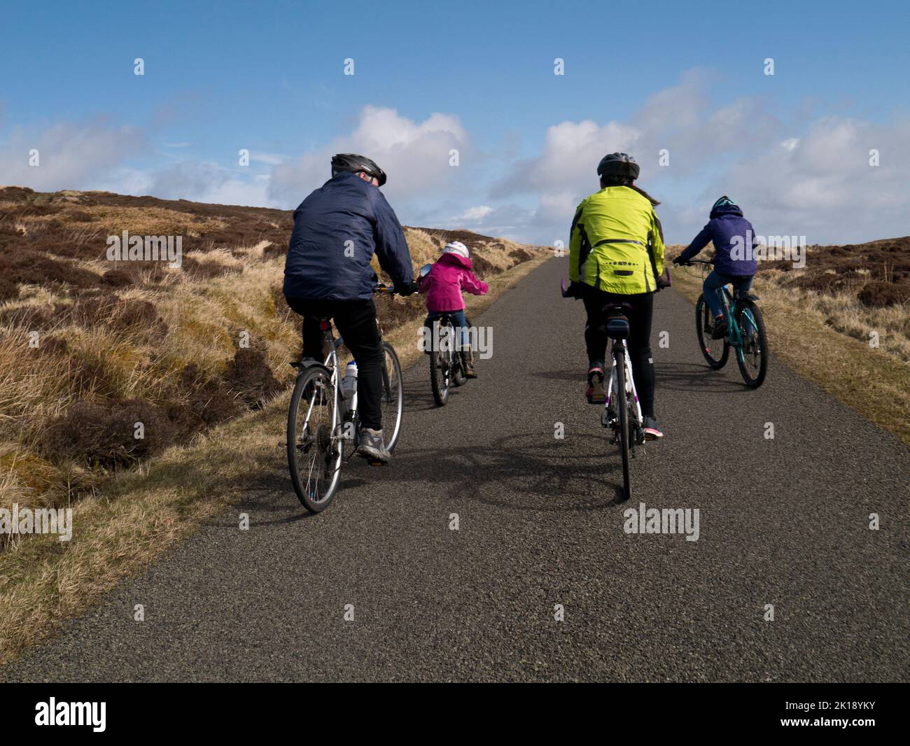 Familia en bicicleta juntos en calles tranquilas, Islas Orkney Foto de stock