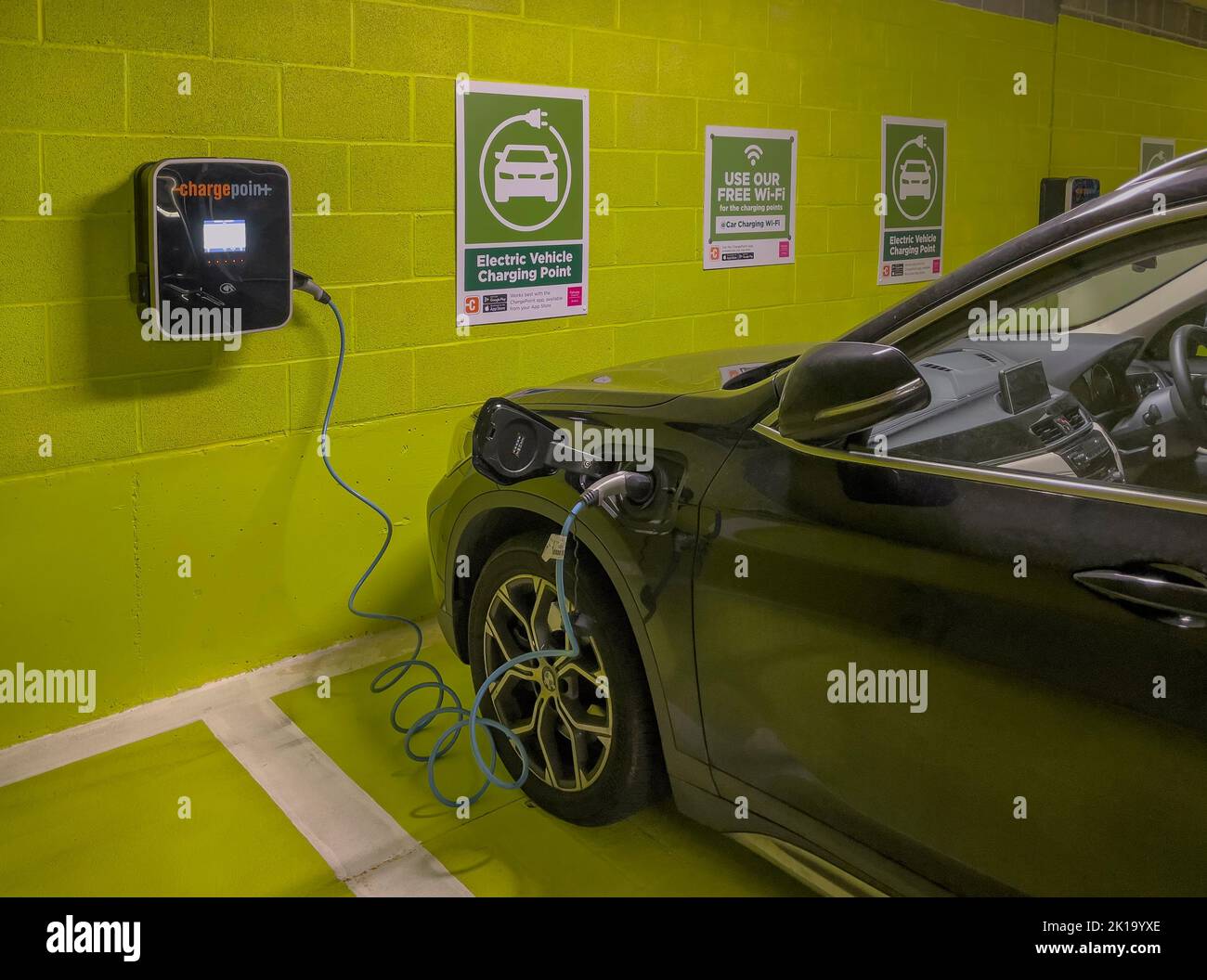 Newbury, Berkshire, Inglaterra, Reino Unido. 2022. Estación de carga de baterías de coche eléctrico en un aparcamiento subterráneo. Foto de stock