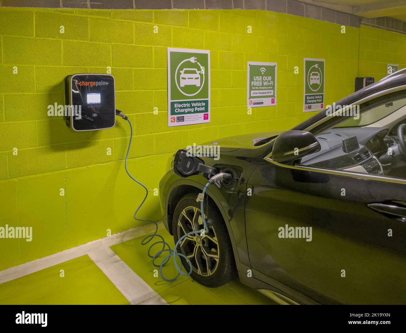 Newbury, Berkshire, Inglaterra, Reino Unido. 2022. Estación de carga de baterías de coche eléctrico en un aparcamiento subterráneo. Foto de stock