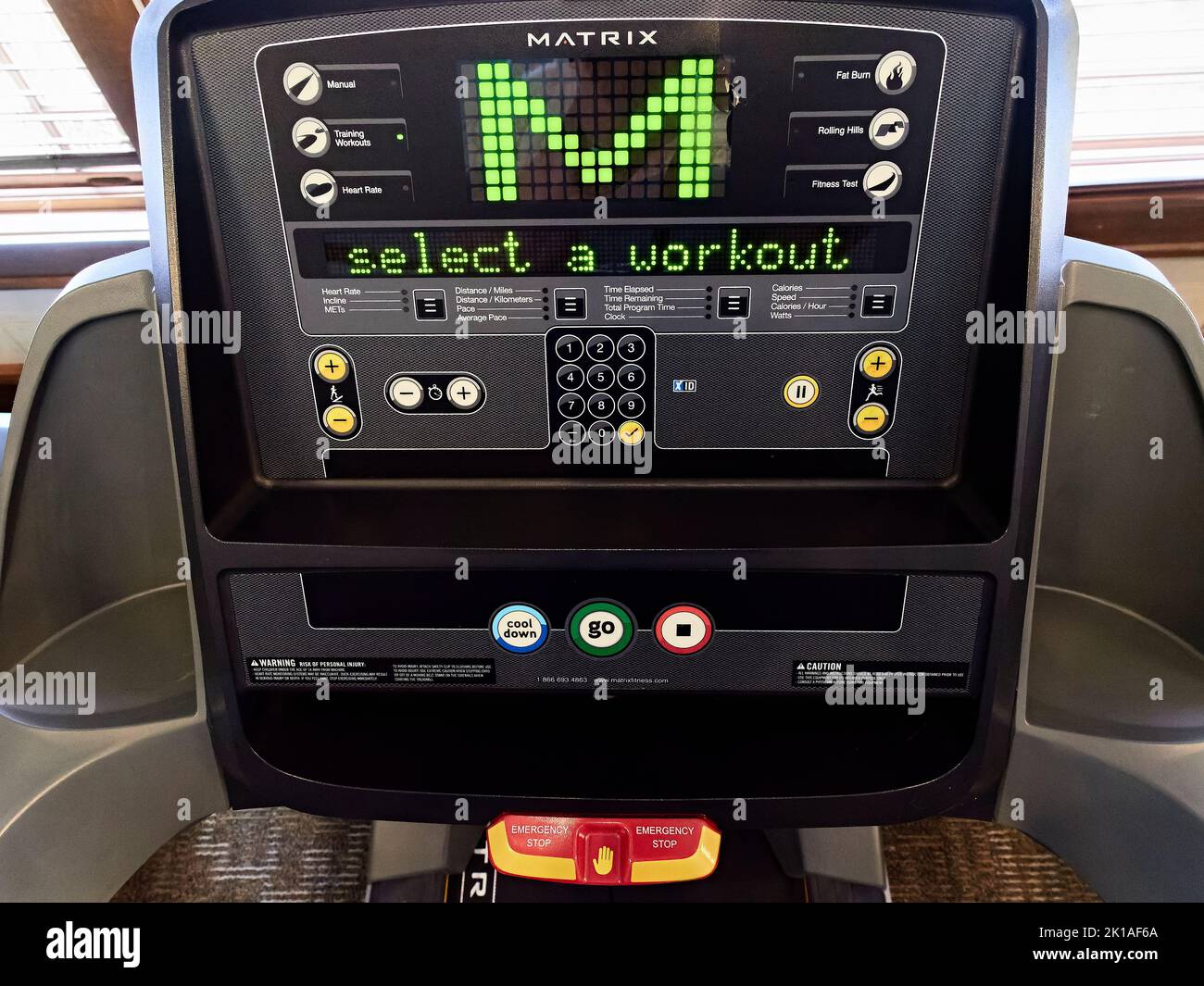 Panel de control en una cinta de correr avanzada Matrix para hacer ejercicio y entrenar en un gimnasio. Foto de stock