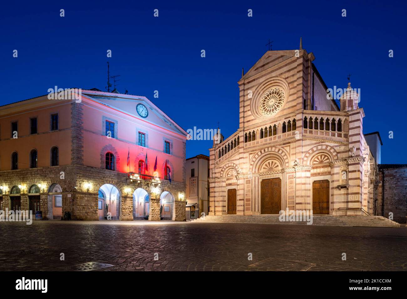 Catedral iluminada, Duomo San Lorenzo, a la izquierda el ayuntamiento de Grosseto, amanecer, hora azul, Grosseto, Toscana, Italia Foto de stock