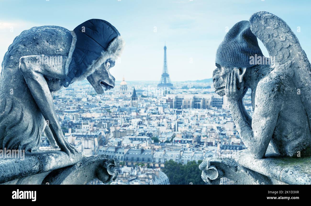 Gárgolas sintiendo frío, París, Francia. Estatuas de demonios en sombreros de invierno en la ciudad congelada, el gas caro y la electricidad en Europa. Concepto de crisis energética, Foto de stock