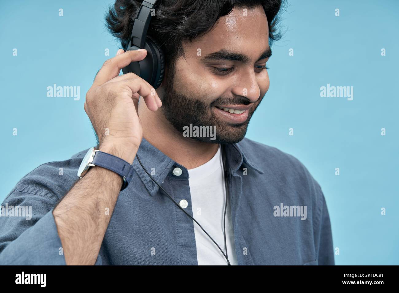Estudiante árabe sonriente con auriculares escuchando música. Primer plano Foto de stock
