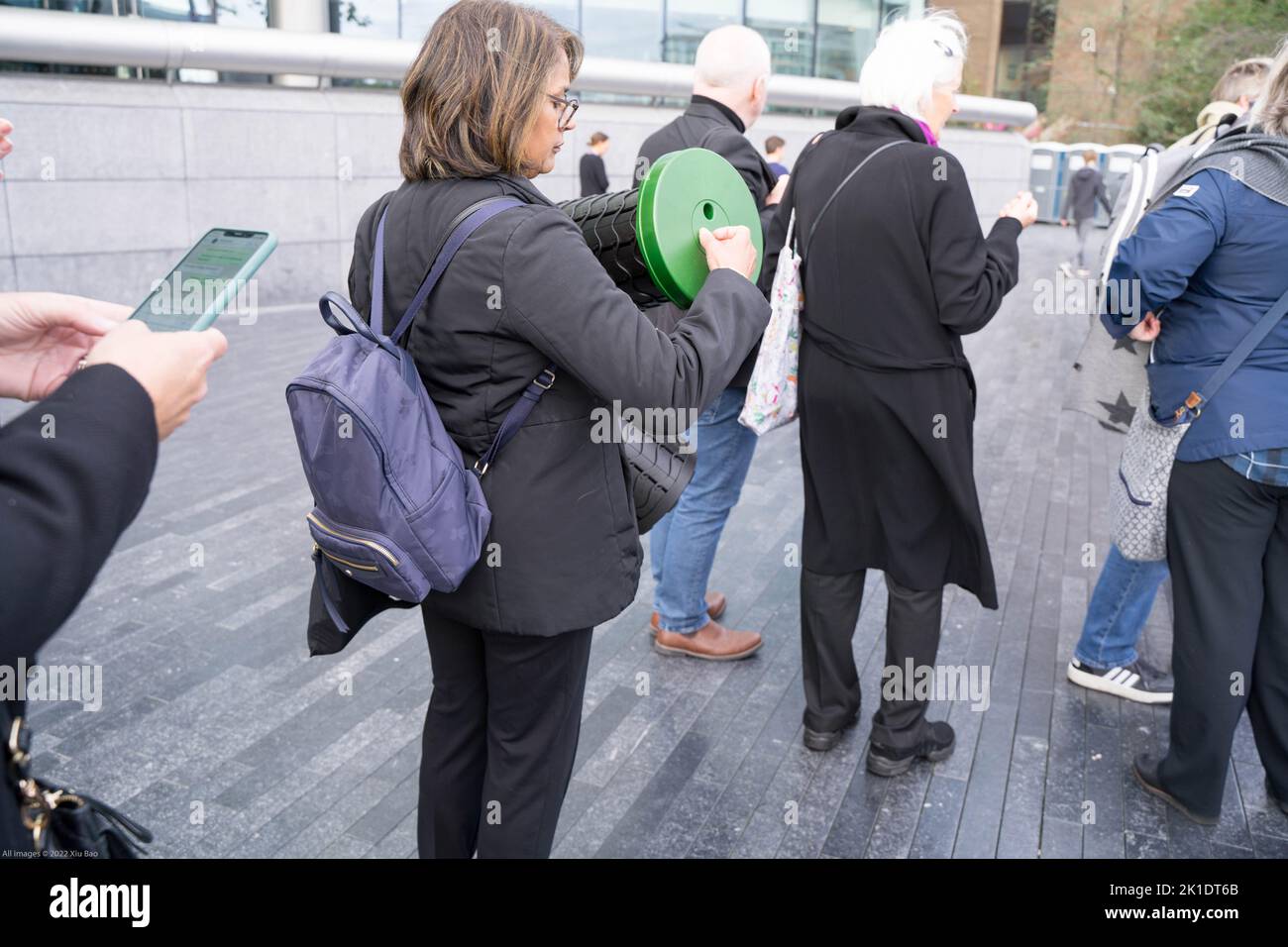 Personas que se unen a las colas a lo largo de la orilla sur del río Támesis para pagar su respeto a la reina que se encuentra en el estado en el salón Westminster de Londres Reino Unido Foto de stock