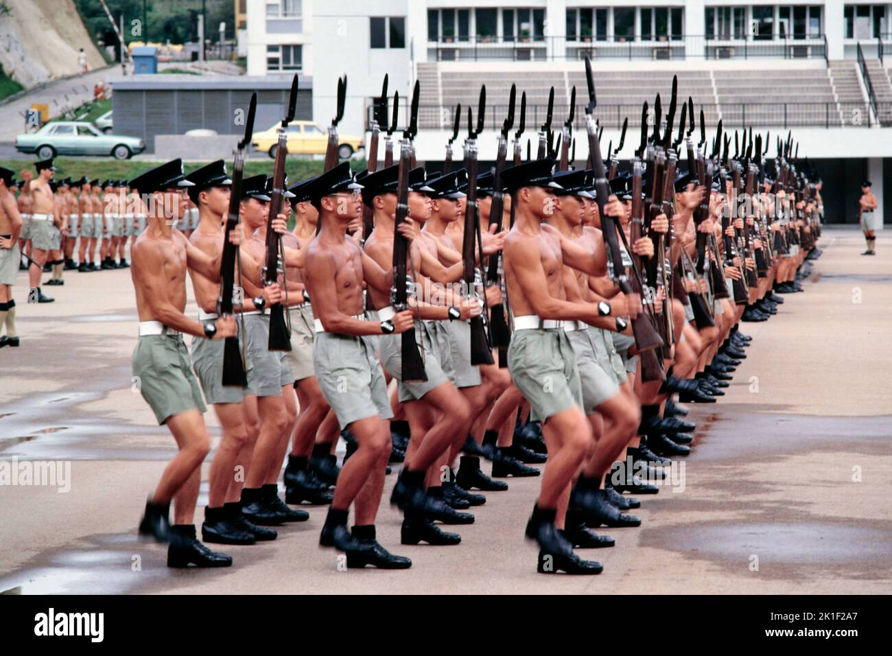 Recluta a los agentes de policía Practique ejercicios de footdrill en la Escuela de Entrenamiento Policial Drill Square, Wong Chuk Hang, Aberdeen, Hong Kong Verano 1984 Foto de stock
