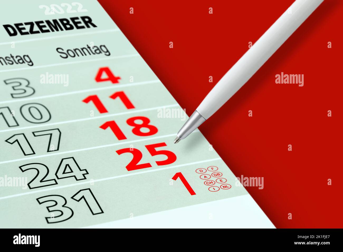 Calendario alemán de Navidad y Nochevieja de 2022 sobre fondo rojo Foto de stock