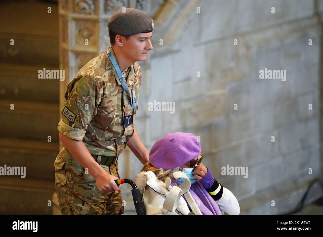 Un miembro del público es empujado en su silla de ruedas por un miembro del ejército para ver el ataúd de la Reina Isabel II, que se encuentra en el estado en la catafalque en Westminster Hall, en el Palacio de Westminster, Londres, antes de su funeral el lunes. Fecha de la foto: Domingo 18 de septiembre de 2022. Foto de stock