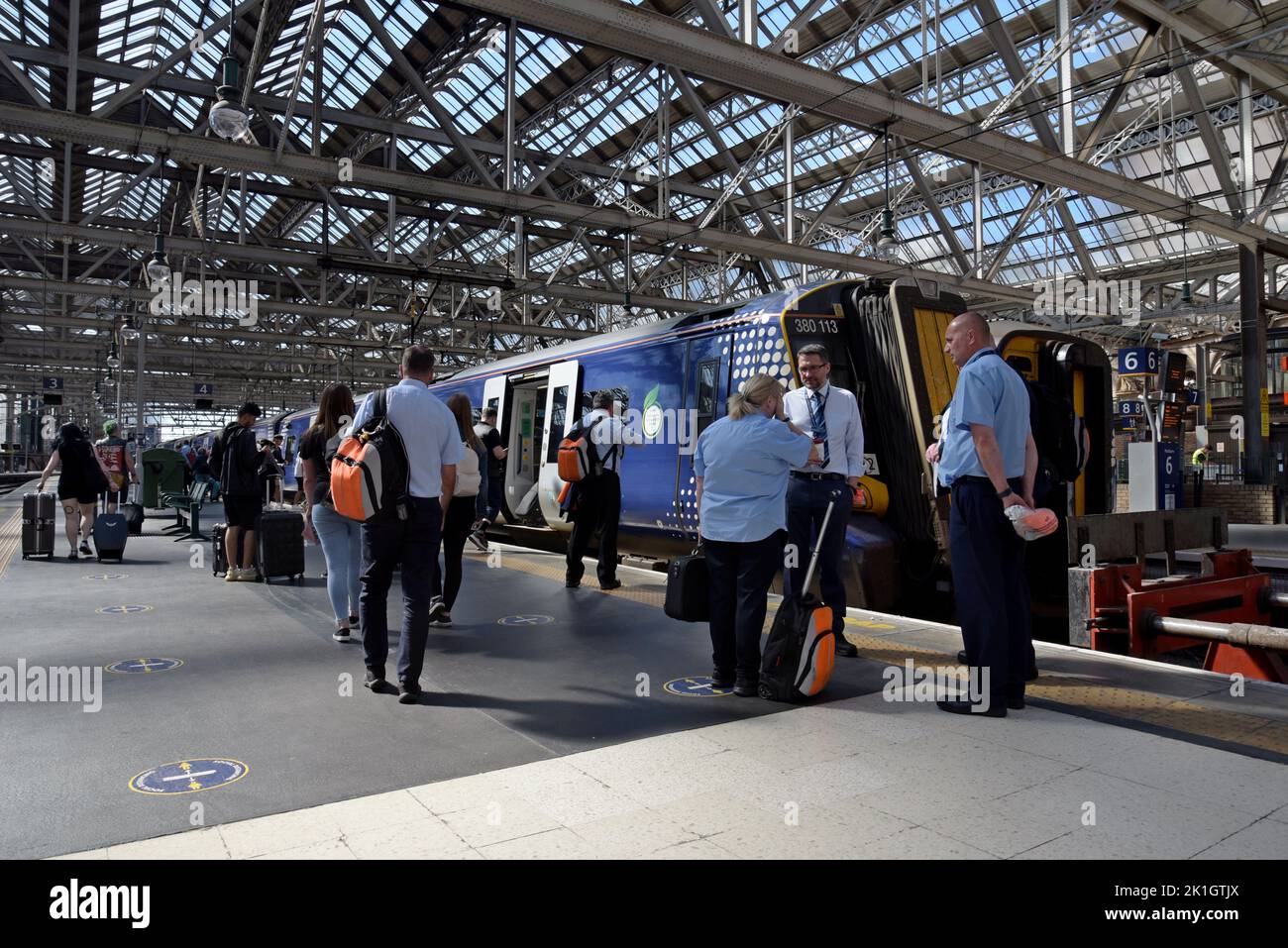 Traincrew charlando mientras los pasajeros suben a un tren eléctrico Desiro Clase 380 en la estación central de Glasgow, Escocia, Reino Unido Foto de stock