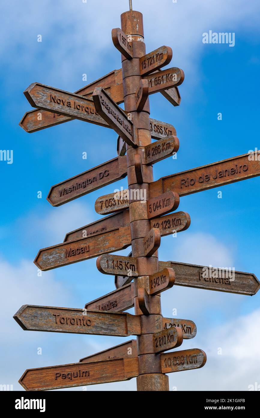 Flechas direccionales en un cartel que indica las distancias a las ciudades del mundo en los terrenos del Outeiro da Memoria, en Angra do Heroismo, Isla Terceira, Azores, Portugal. Foto de stock