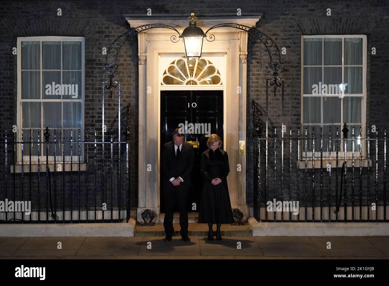 La Primera Ministra Liz Truss y su esposo Hugh O'Leary observan el minuto nacional de silencio en memoria de la Reina Isabel II, en las afueras de 10 Downing Street, Londres. El país guarda un minuto de silencio para recordar a la Reina, con personas invitadas a celebrar la ocasión en casa, en la puerta o en la calle, o en eventos y vigilias comunitarios. Fecha de la foto: Domingo 18 de septiembre de 2022. Foto de stock