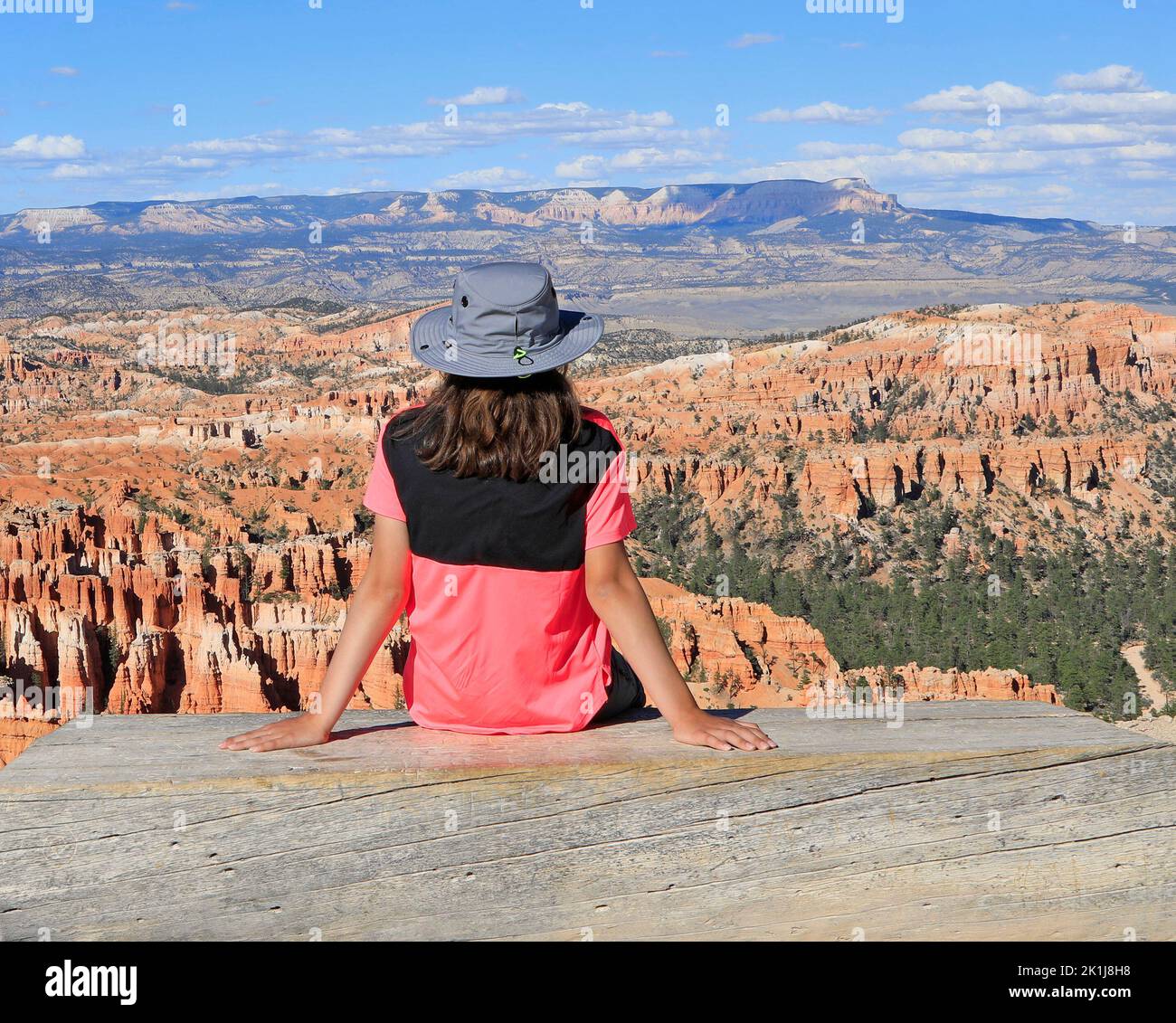 Joven turista de pie en el banco de madera y admirando el paisaje del Cañón Bryce en Utah, EE.UU Foto de stock