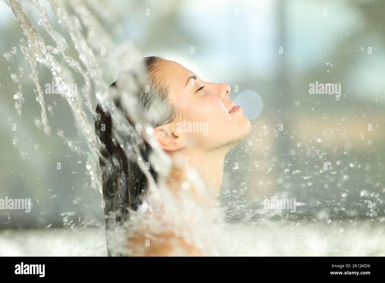 Mujer bajo un chorro de agua en el spa respirando aire fresco Foto de stock