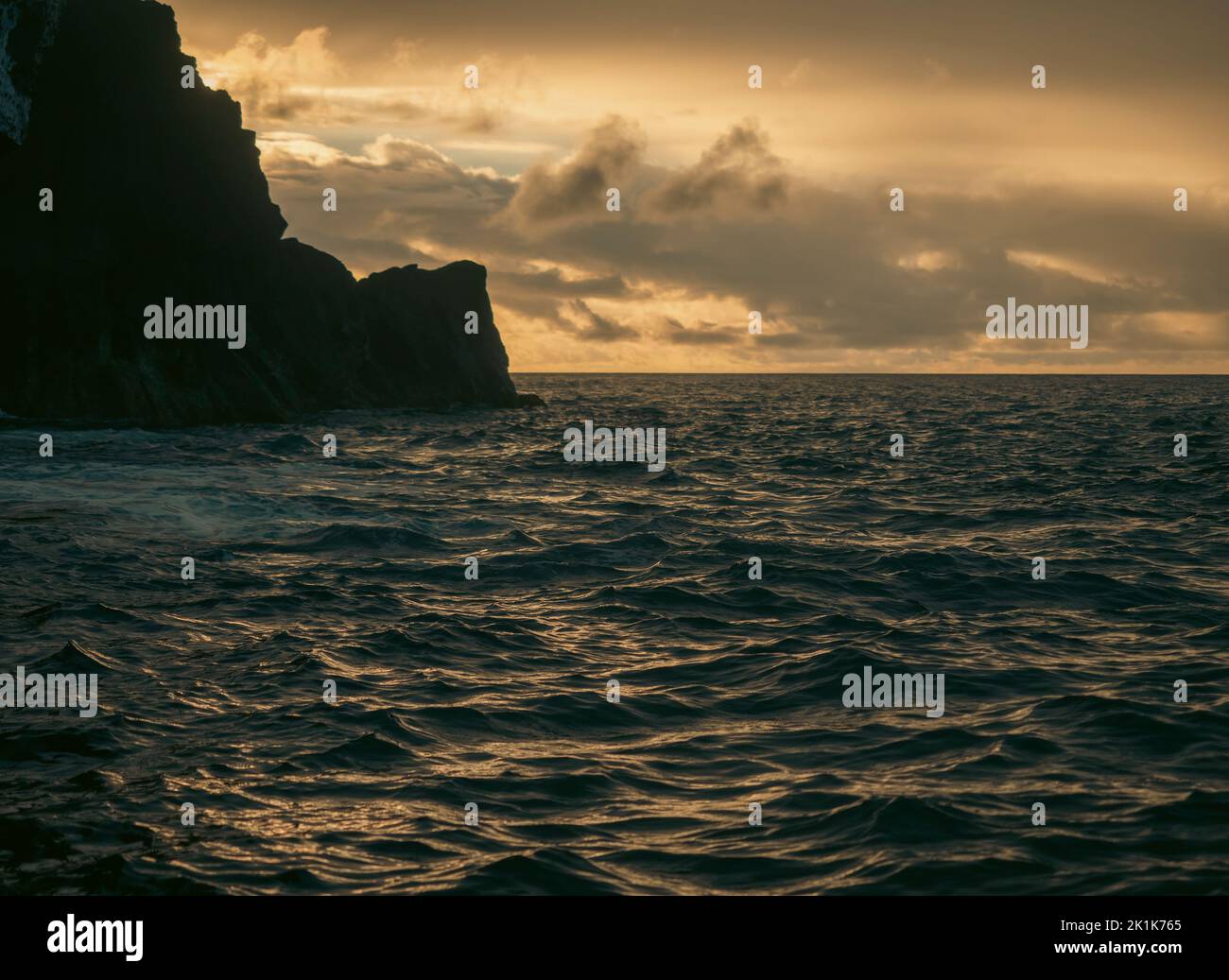 Puesta de sol sobre el océano Atlántico desde las islas portuguesas de las Azores. Una línea costera entrecortada durante la puesta de sol con afloramientos rocosos y una increíble puesta de sol. Foto de stock