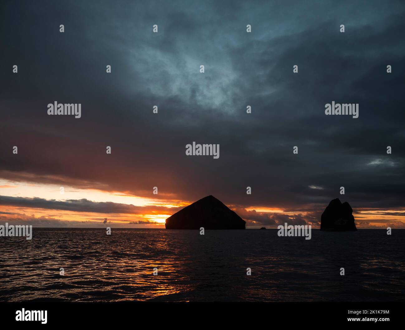 Puesta de sol sobre el océano Atlántico desde las islas portuguesas de las Azores. Una línea costera entrecortada durante la puesta de sol con afloramientos rocosos y una increíble puesta de sol. Foto de stock