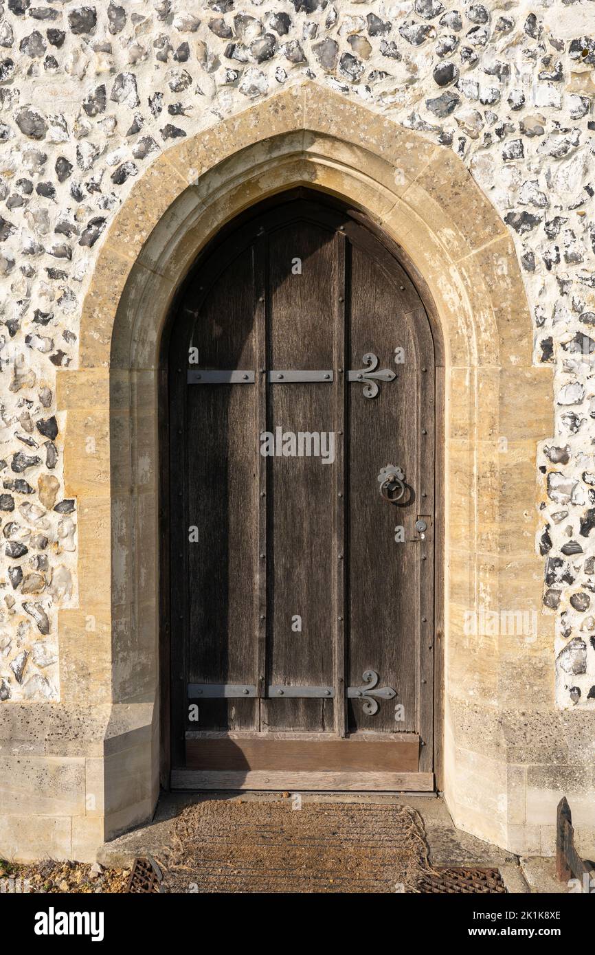 Una antigua puerta de madera y hierro con un marco de piedra en Santa María la Virgen, una iglesia de campo del siglo 12th dentro de las ruinas de la ciudad de Silchester. Hampshire, Reino Unido Foto de stock