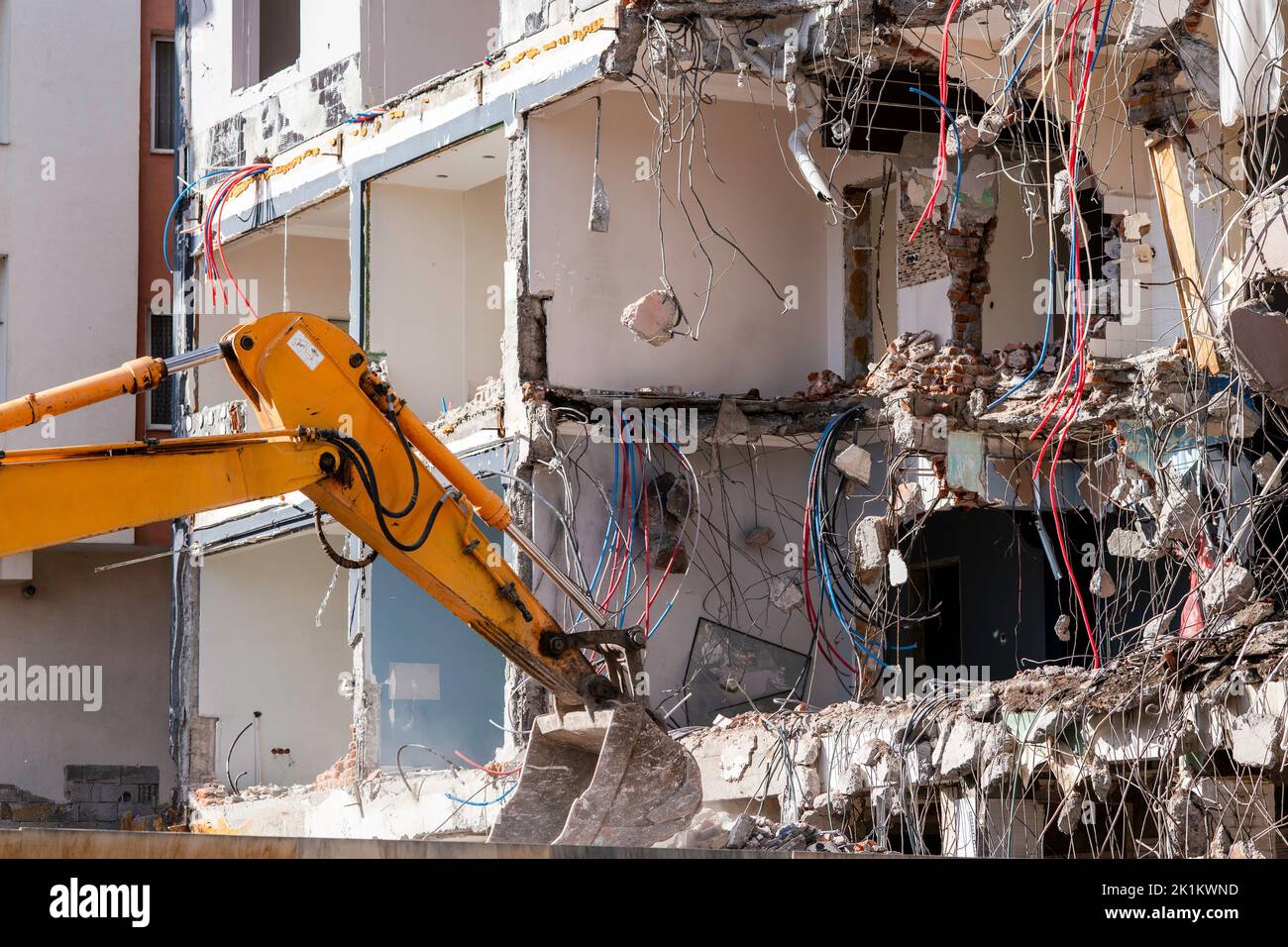 Una pesada máquina de trabajo industrial, digger está destruyendo un viejo edificio abandonado. Fotografía de alta calidad Foto de stock